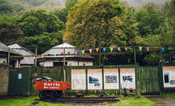 An old slate truck and information boards outside of Corris Mine Explorers based at Corris Caverns in Mid Wales